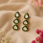 VELQORR emerald green geometric drop earrings with clear stones and gold finish.
