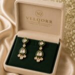 Mira emerald-green Meenakari Polki drop earrings with gold detailing by VELQORR.