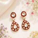 VELQORR ruby red teardrop drop earrings with sparkling clear stones and gold finish.