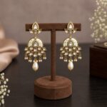 Ivory white Polki-inspired chandbali earrings with pearl drops and gold-tone finish by VELQORR.